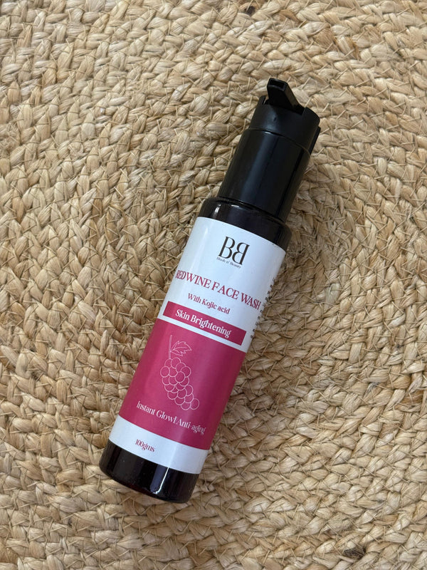 Skincare serum bottle with pink label on a woven mat